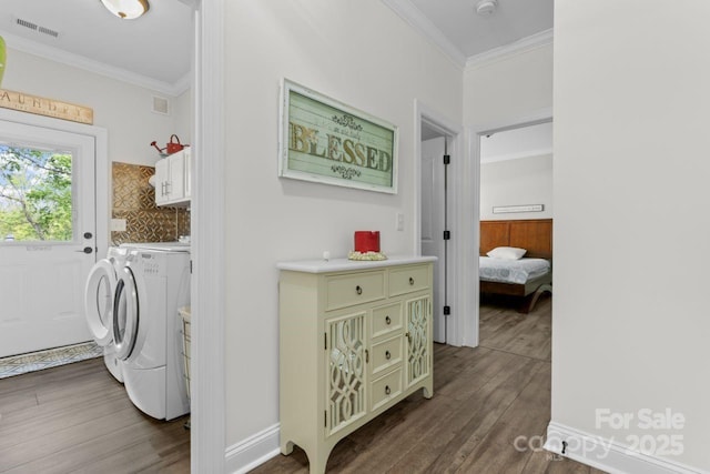 1016 Spanish Moss Rd, Indian Trail, NC 28079 - clothes washing area with cabinet space, washer and dryer, dark wood finished floors, and ornamental molding