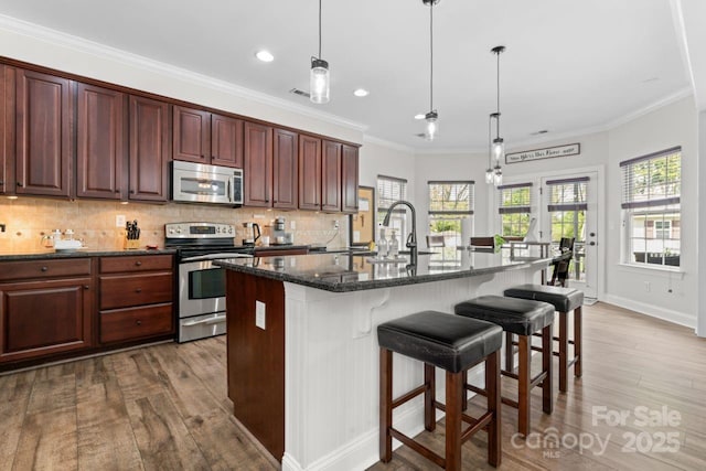 1016 Spanish Moss Rd, Indian Trail, NC 28079 - kitchen with stainless steel appliances, a sink, wood finished floors, tasteful backsplash, and recessed lighting