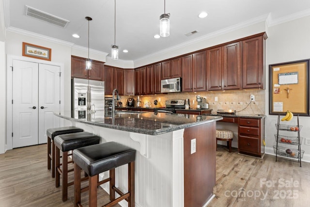 1016 Spanish Moss Rd, Indian Trail, NC 28079 - kitchen featuring stainless steel appliances, a sink, light wood-type flooring, tasteful backsplash, and crown molding