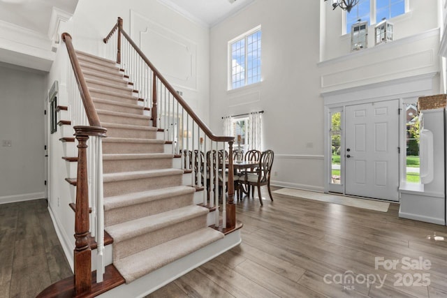 1016 Spanish Moss Rd, Indian Trail, NC 28079 - entrance foyer with stairway, crown molding, wood finished floors, healthy amount of natural light, and a towering ceiling