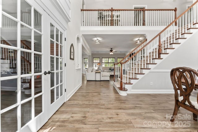 1016 Spanish Moss Rd, Indian Trail, NC 28079 - foyer with french doors, wood finished floors, stairs, a ceiling fan, and baseboards
