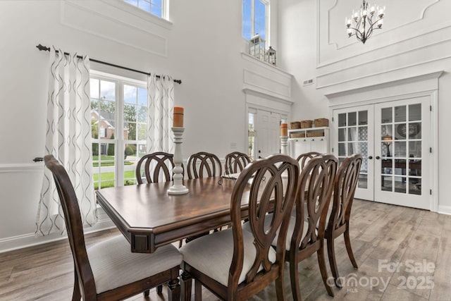 1016 Spanish Moss Rd, Indian Trail, NC 28079 - dining area featuring french doors, wood finished floors, a towering ceiling, plenty of natural light, and a chandelier