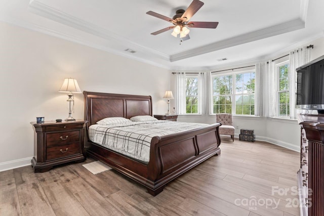 1016 Spanish Moss Rd, Indian Trail, NC 28079 - bedroom featuring a raised ceiling, crown molding, multiple windows, wood finished floors, and baseboards