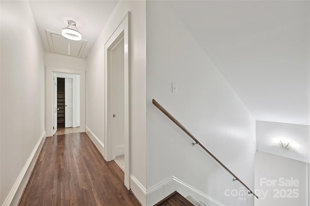hallway with an upstairs landing, attic access, wood finished floors, and baseboards