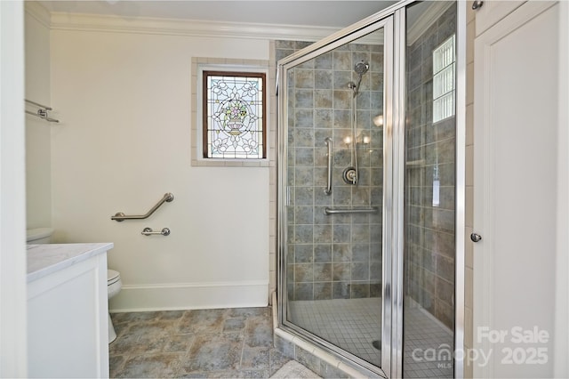 full bathroom with ornamental molding, a shower stall, toilet, baseboards, and vanity