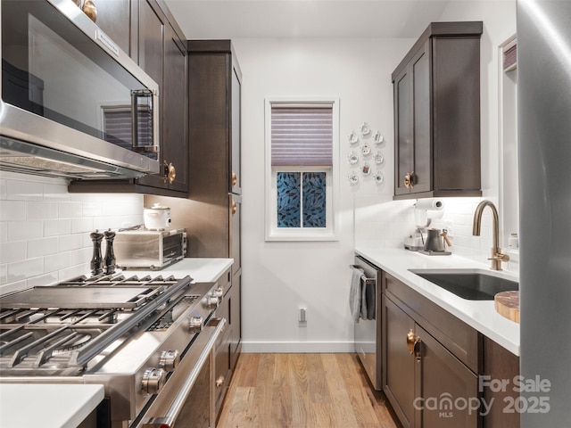 15 Fay Jones Ln, Black Mountain, NC 28711 - kitchen with appliances with stainless steel finishes, a sink, backsplash, light wood-style flooring, and dark brown cabinets