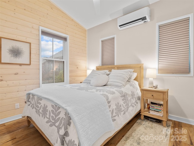 15 Fay Jones Ln, Black Mountain, NC 28711 - bedroom featuring an AC wall unit, vaulted ceiling, wood finished floors, wood walls, and baseboards