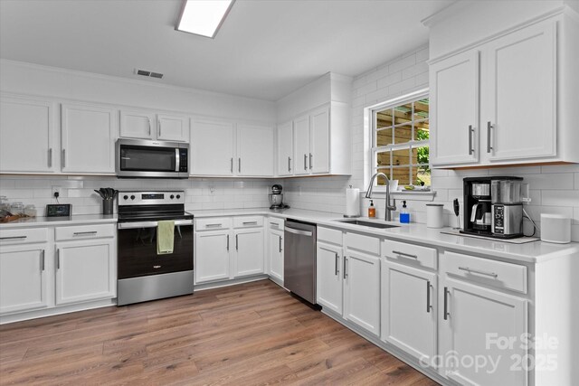 176 Pleasant Grove Ln, Mooresville, NC 28115 - kitchen featuring stainless steel appliances, a sink, decorative backsplash, and white cabinets