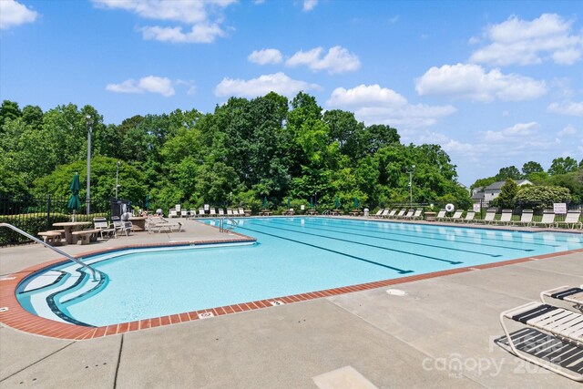176 Pleasant Grove Ln, Mooresville, NC 28115 - community pool with fence, a patio, and view of scattered trees