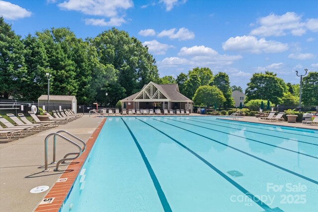 176 Pleasant Grove Ln, Mooresville, NC 28115 - community pool featuring fence, view of wooded area, and a patio