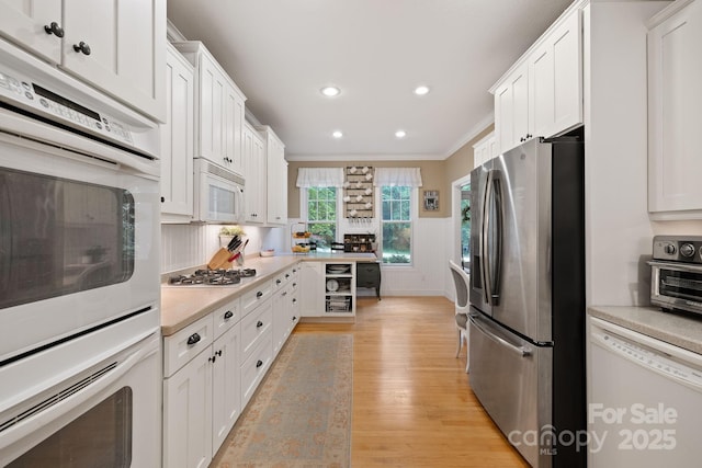 226 Duncan Estate Dr, Fletcher, NC 28732 - kitchen featuring white appliances, ornamental molding, light countertops, light wood-style floors, and white cabinetry