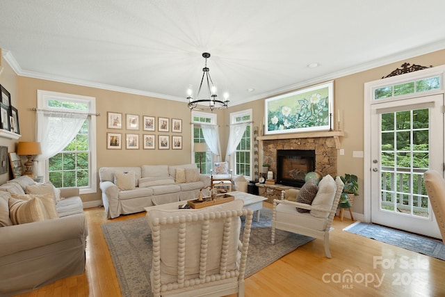 226 Duncan Estate Dr, Fletcher, NC 28732 - living room with light wood-style flooring, a chandelier, crown molding, a stone fireplace, and plenty of natural light