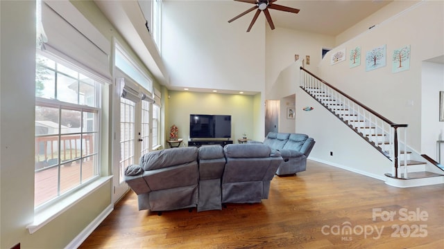 14615 Bridle Trace Ln, Pineville, NC 28134 - living area featuring wood finished floors, stairway, a ceiling fan, a high ceiling, and baseboards