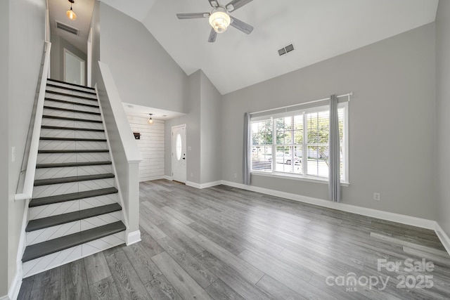 2706 Stagbuck Dr, Gastonia, NC 28052 - unfurnished living room featuring a ceiling fan, stairs, wood finished floors, high vaulted ceiling, and baseboards