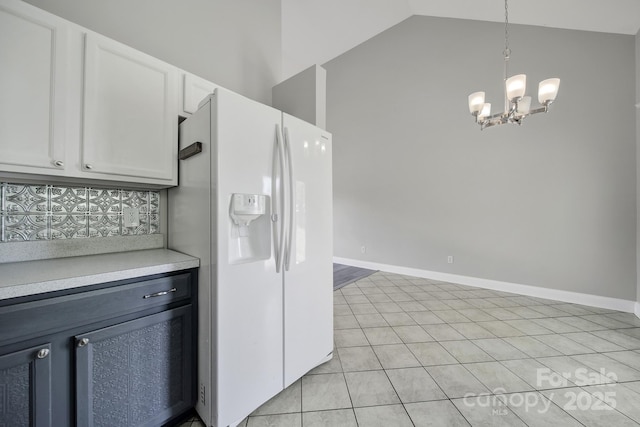 2706 Stagbuck Dr, Gastonia, NC 28052 - kitchen with white fridge with ice dispenser, light countertops, a chandelier, vaulted ceiling, and white cabinetry
