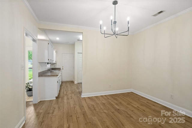 608 Camrose Cir NE, Concord, NC 28025 - unfurnished dining area with a chandelier, light wood-style flooring, and crown molding