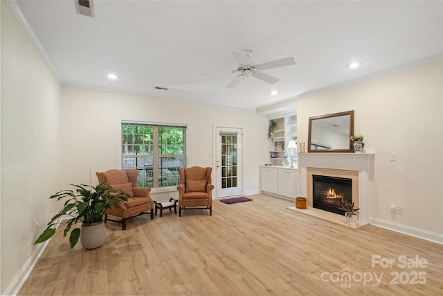 608 Camrose Cir NE, Concord, NC 28025 - living area with ornamental molding, light wood finished floors, ceiling fan, a glass covered fireplace, and recessed lighting
