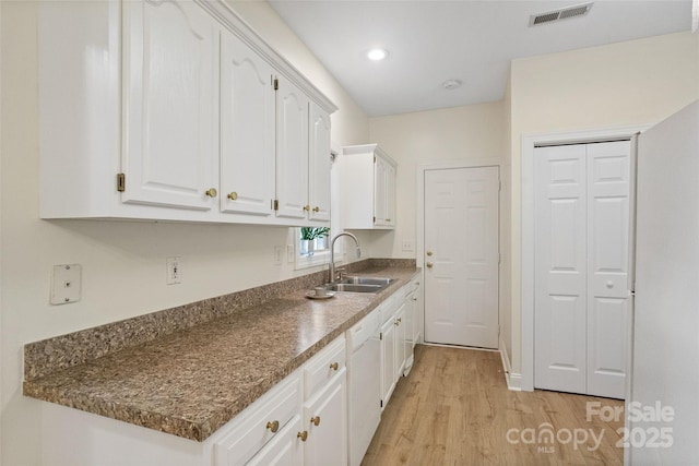 608 Camrose Cir NE, Concord, NC 28025 - kitchen with light wood-style flooring, white cabinets, dishwasher, dark countertops, and recessed lighting