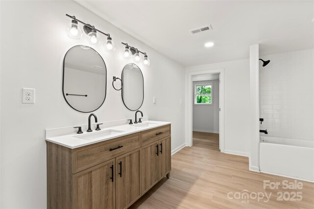 815 E Second Ave, Gastonia, NC 28054 - bathroom with double vanity, shower / washtub combination, and wood finished floors