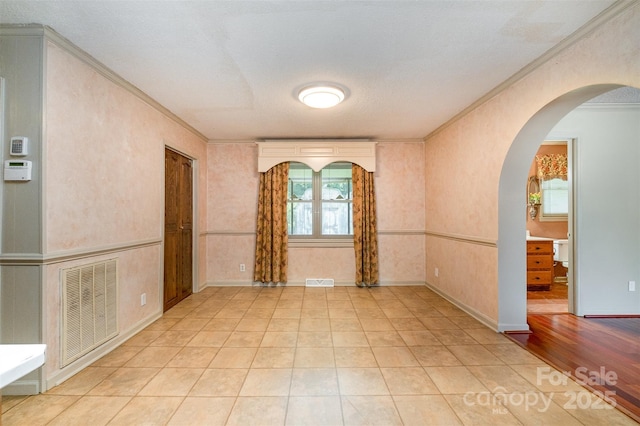 319 Glenhaven Dr, Charlotte, NC 28214 - unfurnished room with arched walkways, ornamental molding, and light tile patterned flooring