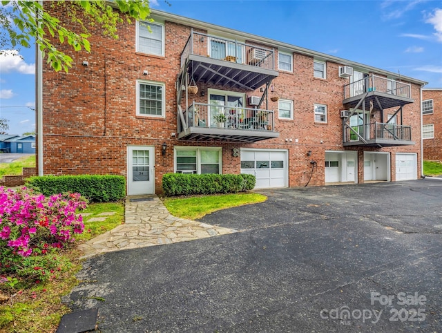 65 Brookside Dr Unit 35, Hendersonville, NC 28792 - view of building exterior featuring an attached garage, driveway, and a wall unit AC
