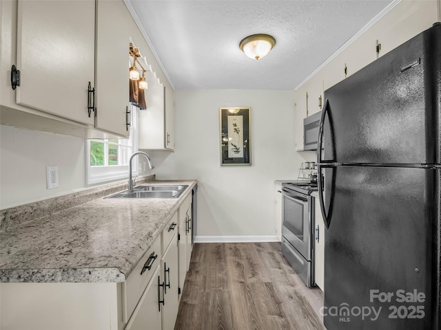 65 Brookside Dr Unit 35, Hendersonville, NC 28792 - kitchen featuring stainless steel appliances, a sink, wood finished floors, light countertops, and a textured ceiling