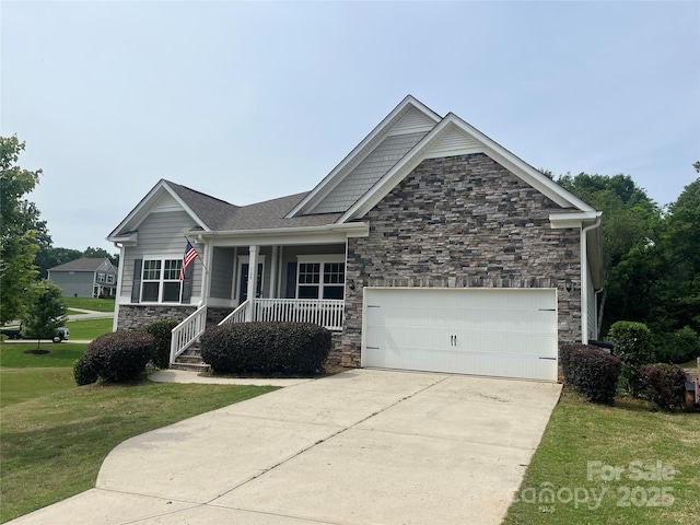 craftsman house featuring stone siding, covered porch, a front lawn, a garage, and driveway