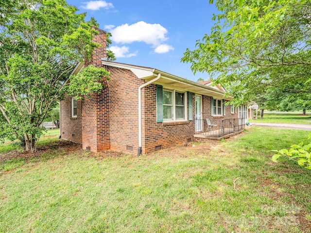 view of front facade with a chimney, crawl space, a front yard, and brick siding