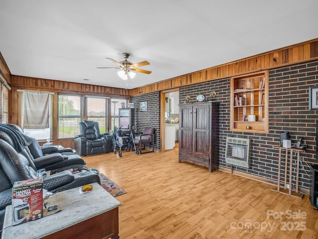 living area with wooden walls, ceiling fan, and light wood finished floors