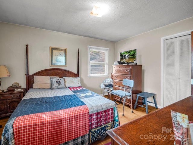 bedroom with a closet, wood finished floors, and a textured ceiling