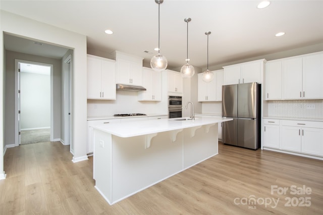256 W Waterlynn Rd, Mooresville, NC 28117 - kitchen with stainless steel appliances, under cabinet range hood, tasteful backsplash, recessed lighting, and light wood-style flooring