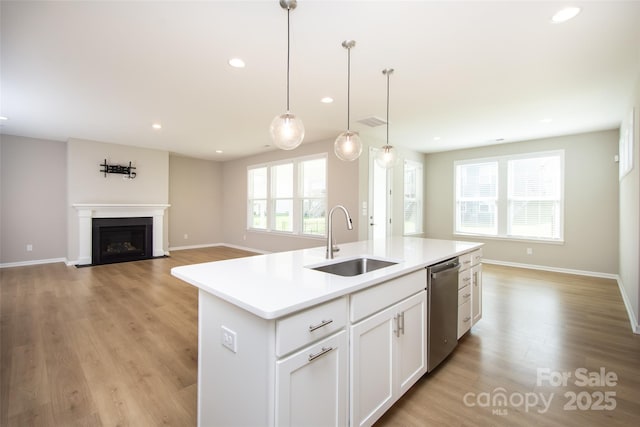 256 W Waterlynn Rd, Mooresville, NC 28117 - kitchen with a sink, stainless steel dishwasher, light wood-type flooring, light countertops, and an island with sink