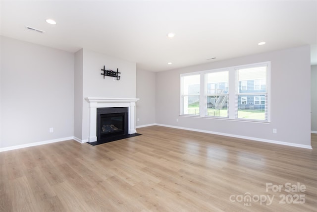 256 W Waterlynn Rd, Mooresville, NC 28117 - unfurnished living room with light wood-type flooring, baseboards, a fireplace with flush hearth, and recessed lighting