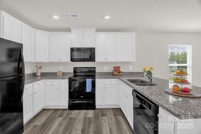 155 Trail Wood Ct, Salisbury, NC 28146 - kitchen featuring black appliances, a peninsula, a sink, light wood finished floors, and white cabinetry