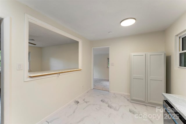 corridor with light marble finish flooring and baseboards