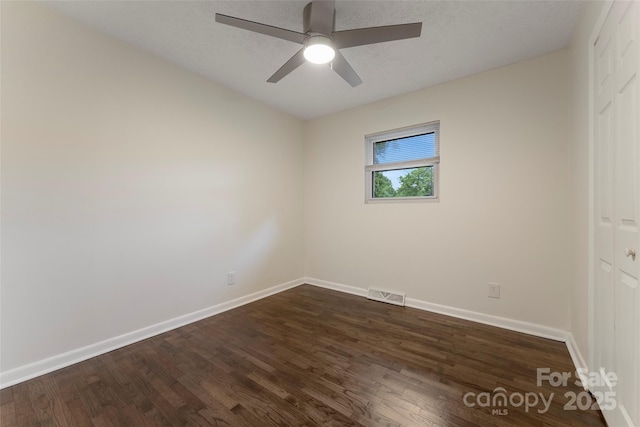 unfurnished bedroom featuring dark wood finished floors, baseboards, ceiling fan, and a closet