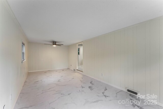 spare room featuring light marble finish flooring and a ceiling fan