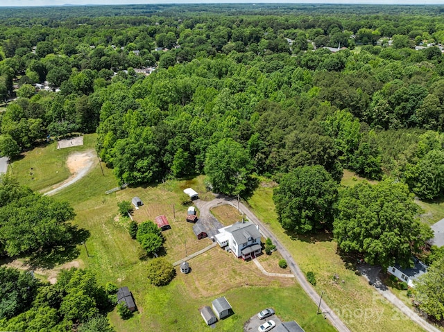 aerial view of property and surrounding area with a heavily wooded area