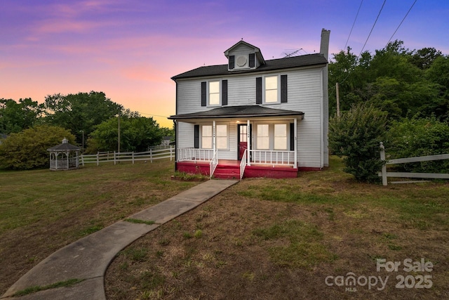 traditional style home with covered porch and a chimney