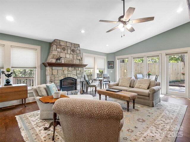 living area featuring lofted ceiling, a fireplace, a ceiling fan, wood finished floors, and recessed lighting