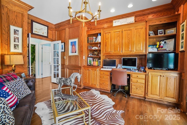 469 Valley Run Dr, Waxhaw, NC 28173 - office featuring a chandelier, wood walls, built in desk, dark wood-style flooring, and built in shelves