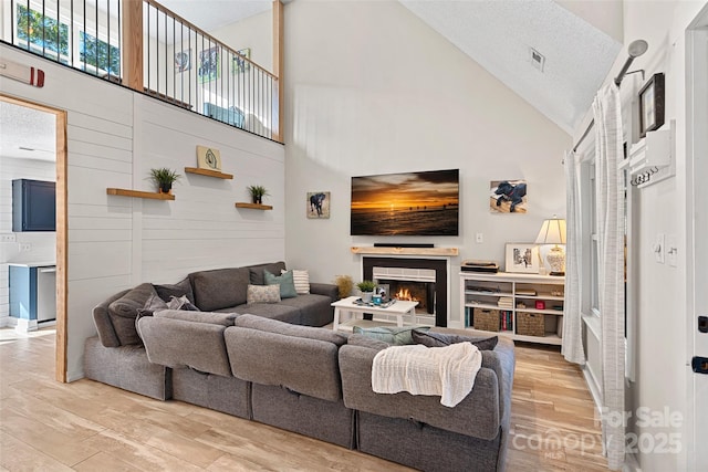 8007 Maxwelton Dr, Huntersville, NC 28078 - living room with high vaulted ceiling, a lit fireplace, and wood finished floors