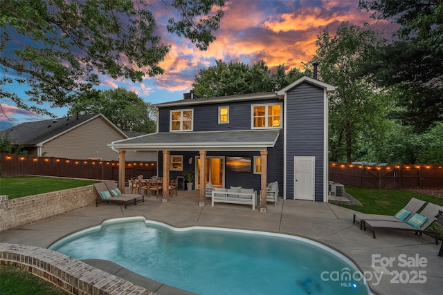 8007 Maxwelton Dr, Huntersville, NC 28078 - back of property at dusk featuring an outdoor hangout area, a patio, and a chimney