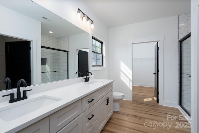 315 W Hoke St W, Landis, NC 28088 - bathroom featuring a shower stall, wood finished floors, double vanity, toilet, and a spacious closet