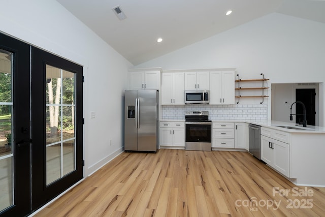 315 W Hoke St W, Landis, NC 28088 - kitchen featuring appliances with stainless steel finishes, a sink, vaulted ceiling, open shelves, and light wood finished floors