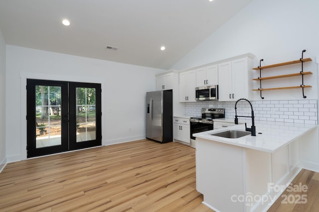 315 W Hoke St W, Landis, NC 28088 - kitchen with appliances with stainless steel finishes, french doors, a sink, backsplash, and light wood-style flooring
