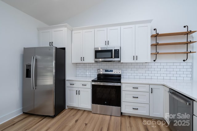 315 W Hoke St W, Landis, NC 28088 - kitchen with stainless steel appliances, lofted ceiling, decorative backsplash, light countertops, and light wood-style flooring