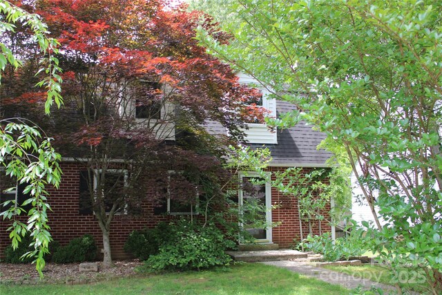 426/432 Maple St, Brevard, NC 28712 - view of property hidden behind natural elements with brick siding and a shingled roof