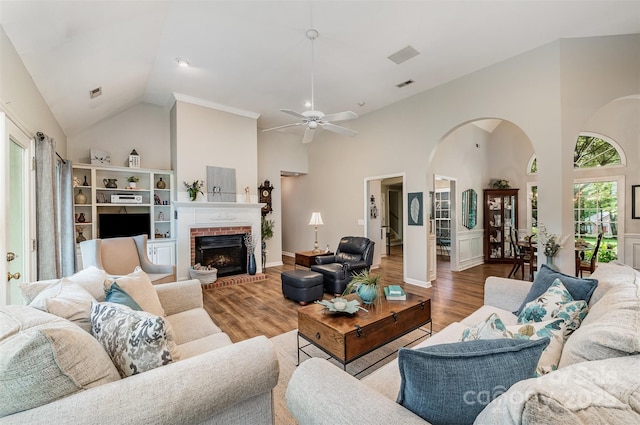 5208 Black Oak Ln, Waxhaw, NC 28173 - living room with high vaulted ceiling, wood finished floors, arched walkways, a ceiling fan, and a brick fireplace