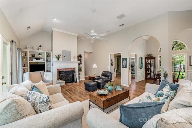 5208 Black Oak Ln, Waxhaw, NC 28173 - living room featuring high vaulted ceiling, arched walkways, wood finished floors, ceiling fan, and a brick fireplace